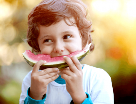a child happily eating a watermelon