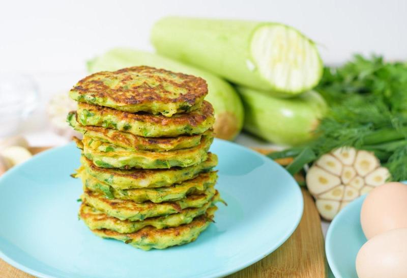 Veggie Fried Pancakes With Zucchini Greens Blue Plate Light Background Wooden Board Top View Selective Focus Space Text